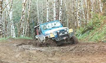 Blue jeep struggling through mud